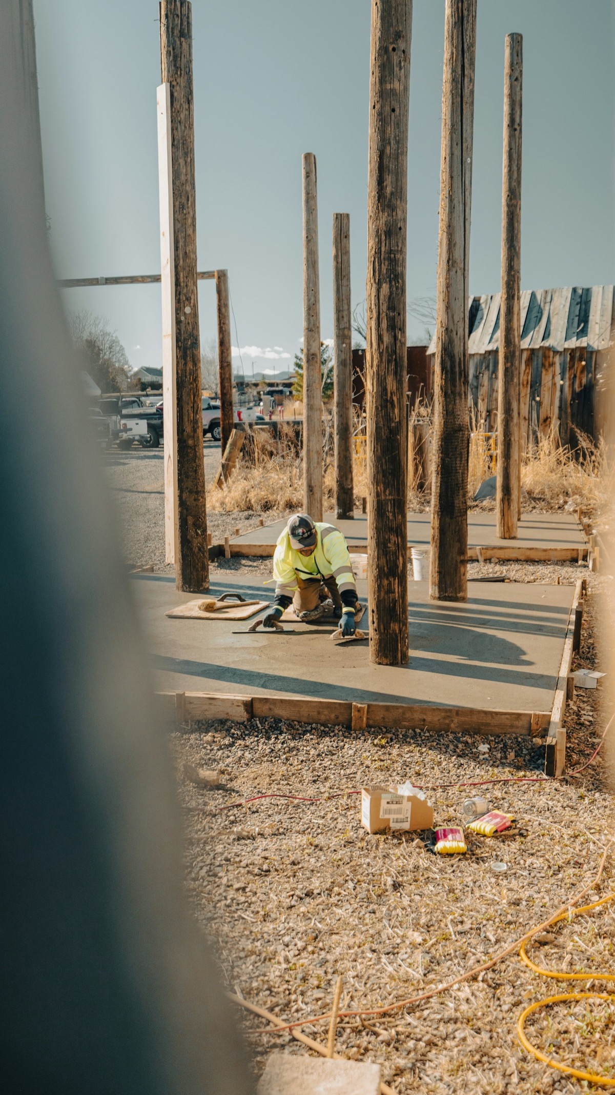 Concreter smoothing a wet concrete slab with finishing tools